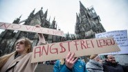 Eine Frau protestiert am 10.01.2016 in Köln vor dem Hauptbahnhof und dem Dom gegen sexuelle Gewalt mit einem Plakat "Angstfrei leben".&nbsp; (picture alliance / dpa / Maja Hitij)